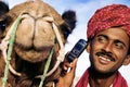 Asian Man and Camel in the Desert with Communications Concept Royalty Free Stock Photo