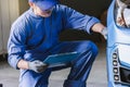 Asian man car inspection Measure quantity Inflated Rubber tires car.Closeup hand holding tire and blue car for tyre pressure Royalty Free Stock Photo