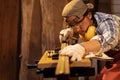 Asian man Carpenter wearing PPE working use measuring tape on timber for marking woodwork furniture in carpentry workshop