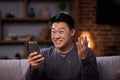 Asian Man celebrating mobile success by showing yes gesture. Excited asian man getting great news, making winner gesture Royalty Free Stock Photo