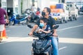 Asian man with child wearing masks while driving bike on the street during covid-19