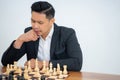 Asian man concentrates on stepping while playing chess