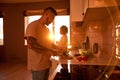 Asian man cutting cucumber for salad near daughter Royalty Free Stock Photo