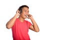 Asian man dances as he listens to his headphones.