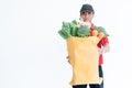 Asian man delivery Holding a paper bag Which contains food and fresh vegetables