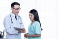 Asian man doctor Explaining treatment procedures And health insurance plans For woman patients Royalty Free Stock Photo