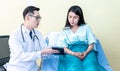Asian man doctor Explaining treatment procedures And health insurance plans For women patients Royalty Free Stock Photo