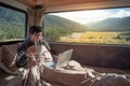 Asian man drinking coffee in camper van