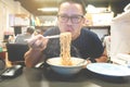Asian man eating instant noodles very hot and spicy