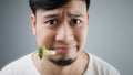 An Asian man eats broccoli. Royalty Free Stock Photo