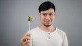 An Asian man eats broccoli. Royalty Free Stock Photo