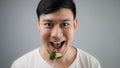 An Asian man eats broccoli. Royalty Free Stock Photo