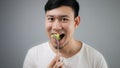 An Asian man eats broccoli. Royalty Free Stock Photo