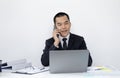 Asian man employee talking on the phone and working in a laptop with a smiling face, Office staff work and telephone conversations Royalty Free Stock Photo