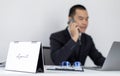 Asian man employee talking on the phone and working in a laptop with a smiling face, Office staff work and telephone conversations Royalty Free Stock Photo