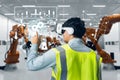 Asian man engineer worker wearing VR headset working control robotic  industrial in factory Royalty Free Stock Photo