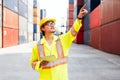 Asian man engineer working with tablet and point up at containers at a container yard. Shipping business management. Royalty Free Stock Photo