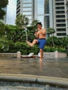 Asian strong masculine professional man practiced Tai kick boxing in the park