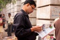Asian man flips through the magazine on the street