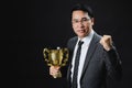 Asian man in formal suit happy with trophy