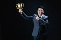 Asian man in formal suit holding trophy