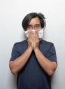 Asian man getting cold or flu,he is coughing to clear throat with hand holding tissue paper closing his mouth isolated on white Royalty Free Stock Photo