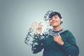 Asian man in green sweater wearing headset listen to music of dissolving into pixels on gray background Future technology Concept Royalty Free Stock Photo