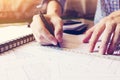 Asian man hand drawing on blueprint paper at home office.