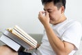 Asian man has problems with eye strain,vision disorders while reading books for too long,dry eyes and irritated pain,massaging Royalty Free Stock Photo