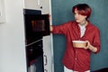 Asian man heating food in microwave at home Royalty Free Stock Photo