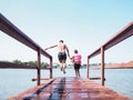 Asian man and his sister jumping off wooden bridge Royalty Free Stock Photo