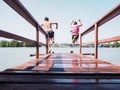 Asian man and his sister jumping off wooden bridge Royalty Free Stock Photo