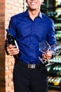 Asian man holding bottle of wine Royalty Free Stock Photo