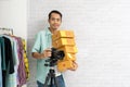 Asian man holding camera with carry brown parcel or cardboard boxes