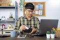 Asian man holding credit card and typing information on internet with laptop at home, online shopping concept Royalty Free Stock Photo