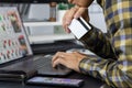 Asian man holding credit card and typing information on internet with laptop at home, online shopping concept Royalty Free Stock Photo