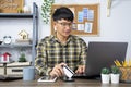 Asian man holding credit card and typing information on internet with laptop at home, online shopping concept Royalty Free Stock Photo