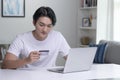 Asian man holding credit card and using laptop computer. Businessman working at home.Online shopping, e-commerce, internet banking Royalty Free Stock Photo