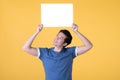 Asian man holding empty blank board isolated on yellow background Royalty Free Stock Photo