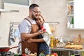 Asian man holding red box with ring making propose to his girlfriend in the kitchen Royalty Free Stock Photo