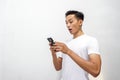 Asian man holding smartphone and shocked about discount or cash back from online shop