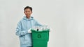 Asian man holding trashcan with plastic garbage