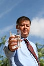 Asian Man Holds a Glass of Water Over the Blue Sky Royalty Free Stock Photo