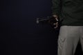 Asian man holds a gun. Gun in his hand. Killed shooting his target isolated on black background Royalty Free Stock Photo