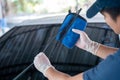 Asian man holds the microfiber in hand and wipe the windshield wipers the car, Car wash service concept Royalty Free Stock Photo