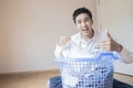 Asian man husband working homework.He is preparing clothes in basket to wash to washing machine for service lifestyle family