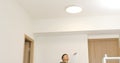 Asian Man install lamp onto the ceiling Royalty Free Stock Photo