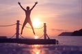 Asian man jumping on floating pier at sunrise , Silhouette body of asian people early morning on the beach by the sea Royalty Free Stock Photo