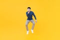 Asian man jumping in mid-air doing pointing gesture