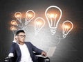 Asian man with laptop and chain of light bulbs Royalty Free Stock Photo